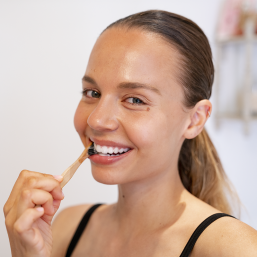 Femme qui se brosse les dents avec notre Dentifrice Solide à Croquer - 100 pastilles - Savonnerie des Collines